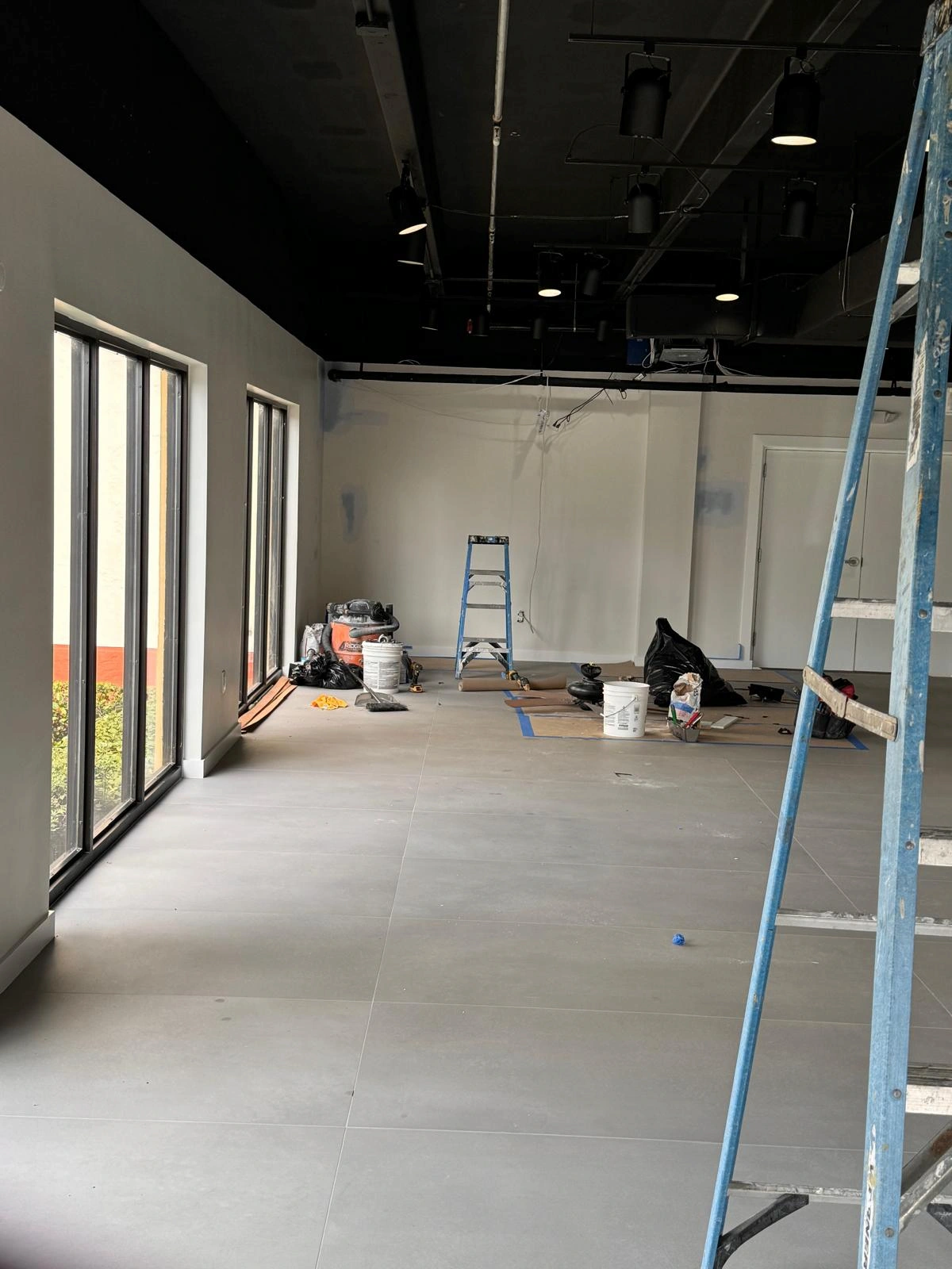 New construction homes in Stuart FL — the PSL House custom build by Nakamura Contractors at the drywall stage, with scaffolding and roughed-in plumbing